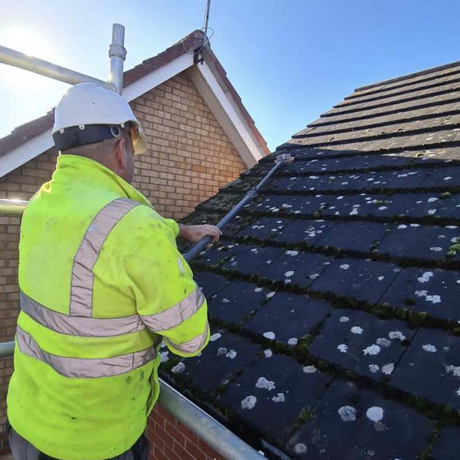 Scrubbing off roof moss